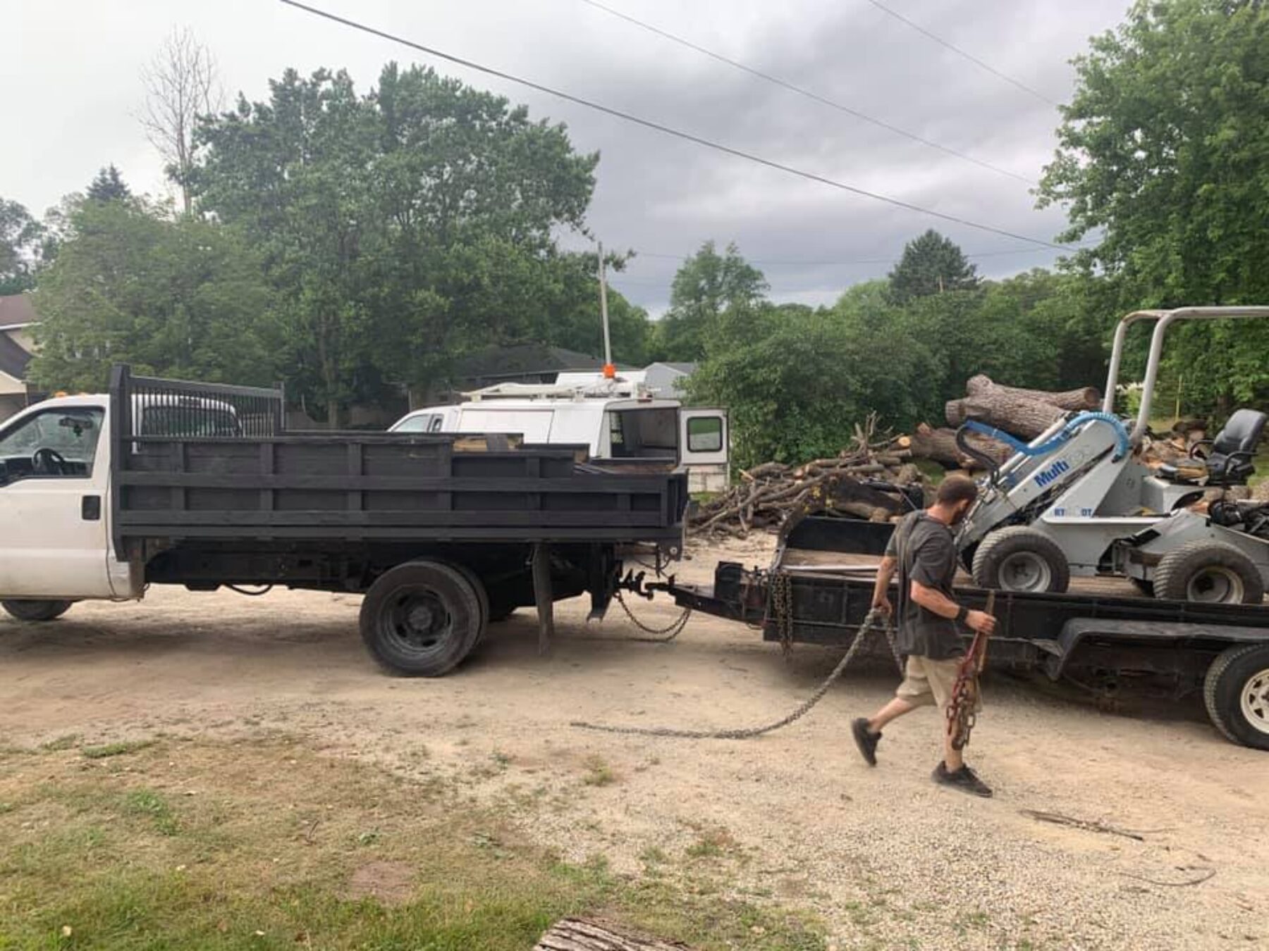 Tree Top climber employee pulling large chain across the ground